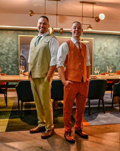 Two men in formal attire standing in a restaurant setting